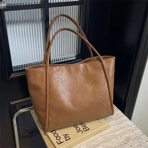 Macro detail of brown leather tote bag with vintage texture on artistic book background
