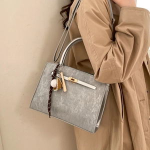 Silver metallic textured Kelly style handbag with golden clasp and sports charm