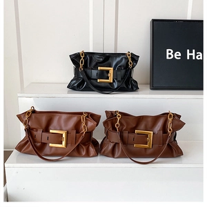 Détail des grandes boucles dorées sur des sacs cabas en cuir plissé noir et marron