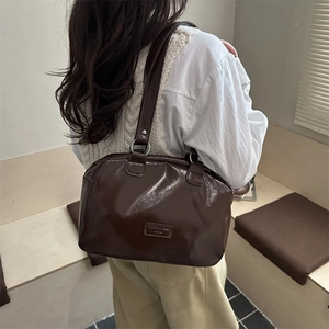Brown waxed leather tote bag with a high-shine finish and long shoulder straps for women