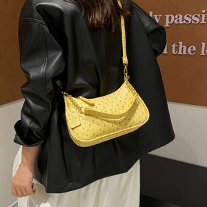 Yellow ostrich pattern baguette bag with chain strap shown on a model in a modern style