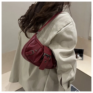 Detail of vintage red pleated shoulder bag with large metal buckle on high quality PU leather