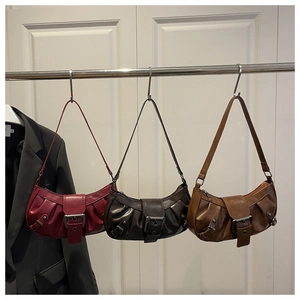 Three pleated crescent shoulder bags in burgundy, coffee, and tan with metal buckle details
