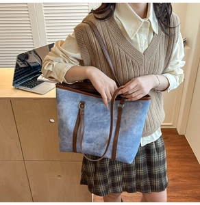 French style vintage blue tote bag with brown leather straps in a cozy indoor scene