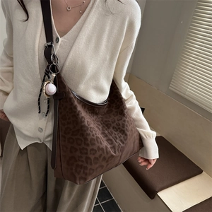 Retro leopard print tote bag with brown leather trim and baseball charm accessory