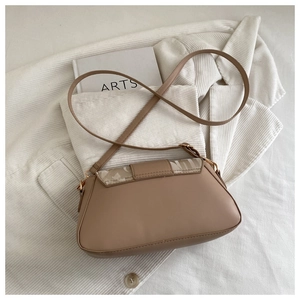 Détail d'un sac bandoulière marron avec rabat géométrique sur une veste en velours côtelé