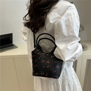 Fashionable black cherry print bucket bag with dual handles and long shoulder strap