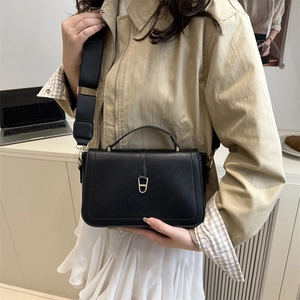 Sac à bandoulière en cuir PU noir avec boucle dorée présenté sur un mannequin