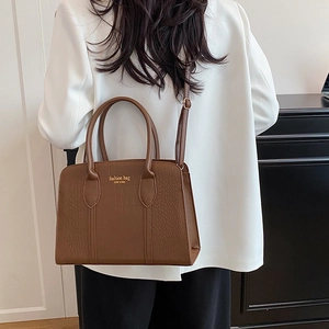 Brown crocodile embossed tote handbag with New York logo shown on a model