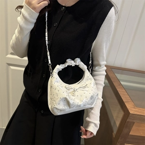 White ruched handle handbag with lace texture, bow detail and pearl charm shown on model