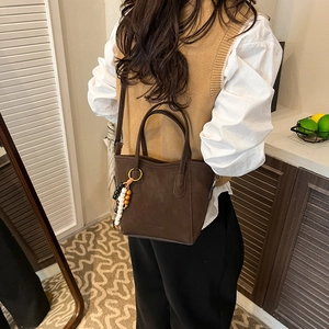Elegante borsa tote in pelle scamosciata marrone scuro con ciondolo vista laterale