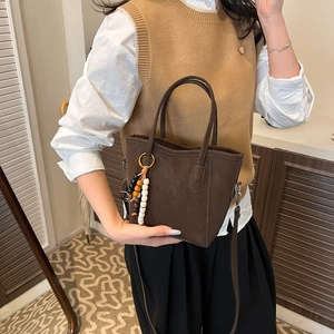 Minimalist dark brown suede bucket bag with beaded charm for daily casual commute