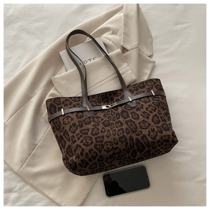 Detailansicht der Leopard-Print Shopper Tasche mit Lederriemen auf einem beigen Blazer