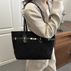 Sac fourre-tout noir mat avec boucle dorée porté à l'épaule pour le style professionnel