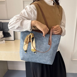 Blue denim tote bag with brown leather handles and a geometric silk scarf for women
