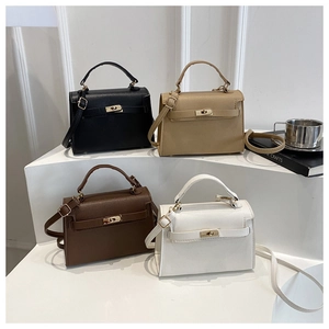 Detail of four leather handbags in black, khaki, brown, and white with metal locks
