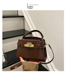 Detail of coffee brown oil-wax leather handbag featuring a golden turn-lock closure