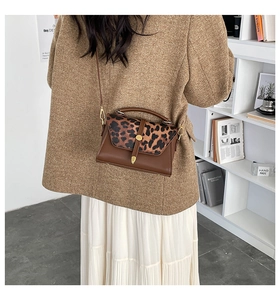 Detail of a vintage small square crossbody bag with brown leather and leopard print flap