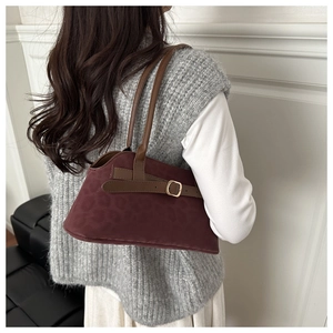 Detail view of burgundy leopard print suede shoulder bag with gold metal buckle and strap