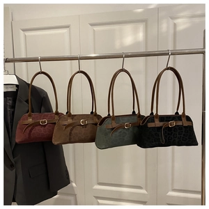 Detail of four vintage suede handbags in leopard print with decorative buckles and straps
