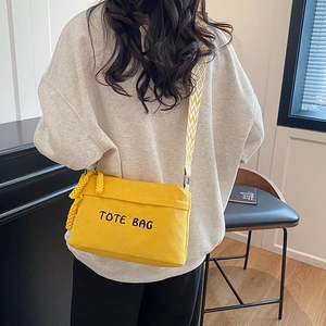 Yellow corduroy tote bag with black TOTE BAG embroidery and wide geometric strap
