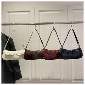 Detail of glossy patent leather shoulder bags in four colors with buckle flap pockets