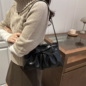 Black leather bow shoulder bag with silver star buckle shown with casual autumn knitwear