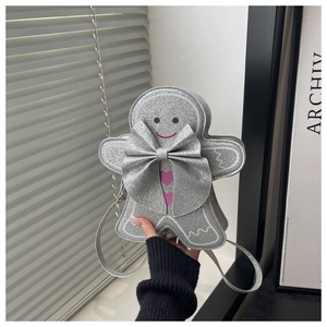 Gros plan d'un sac bandoulière bonhomme de pain d'épices à paillettes argentées et nœud rose