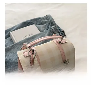 Detail of pink plaid mini backpack featuring star buckle and plush rabbit pendant