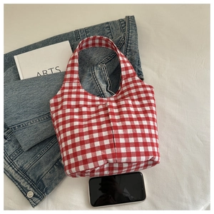 Détail du sac cabas en toile à carreaux rouges et blancs avec poches et texture de tissu