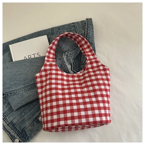 Détail du sac cabas en toile à carreaux vichy rouge et blanc avec veste en jean