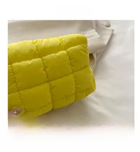 Macro detail of vibrant yellow quilted down fabric with stylish square stitching texture