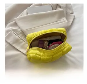 Quilted down nylon cosmetic bag in bright yellow showing spacious interior storage
