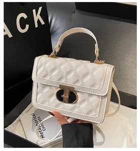 Quilted beige square crossbody bag with gold lock displayed in a premium gift box setup