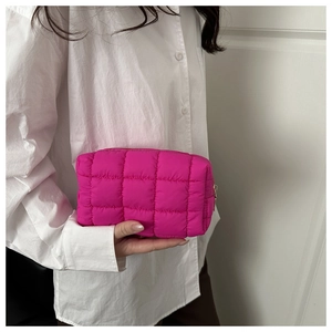 Close-up of rose pink quilted nylon clutch with golden zipper and puffy grid pattern