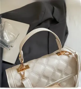 Close-up of white quilted leather texture with gold metal buckle and handle link