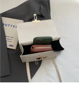 Interior view of white quilted crossbody bag showing storage space for phone and wallet