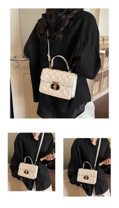 Detailed view of quilted leather handbag featuring a gold buckle and elegant top handle
