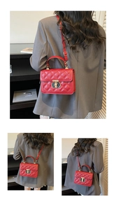 Detail of red quilted crossbody bag with a golden circular buckle and adjustable strap
