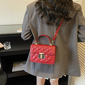 Red quilted crossbody bag with metal lock shown on shoulder for professional styling