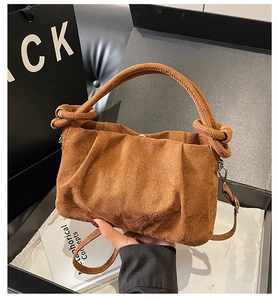 Close-up of brown suede ruched cloud bag with knot handle and detachable shoulder strap