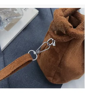 Close-up of vintage brown suede shoulder bag with high-quality silver lobster clasp hardware