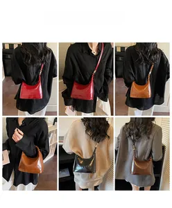 Detail view of glossy leather handbags in red, black, and brown with embossed letters