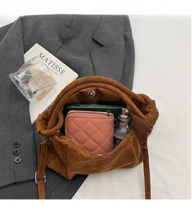 Interior view of brown suede shoulder bag showing storage for phone and wallet