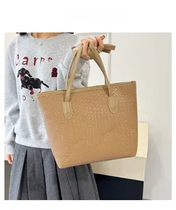 Detailed view of cream woven tote bag showing large capacity on model in gray hoodie