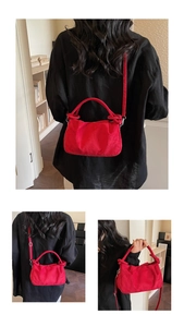 Close-up of red pleated cloud bag with unique thick knotted handle and soft velvet texture