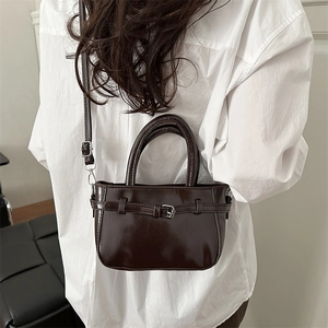 Glossy dark brown patent leather handbag with metal buckle and detachable shoulder strap
