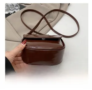 Dettaglio del fondo resistente all'usura di questa borsa a tracolla in vernice marrone