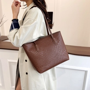 Brown woven texture large tote bag for women worn with a beige trench coat
