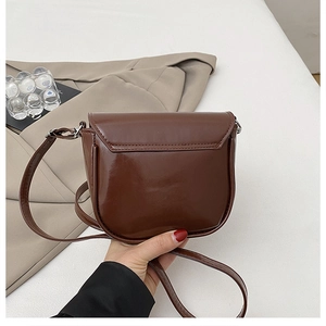 Gros plan détaillé d'un sac besace marron foncé avec finition brillante et couture